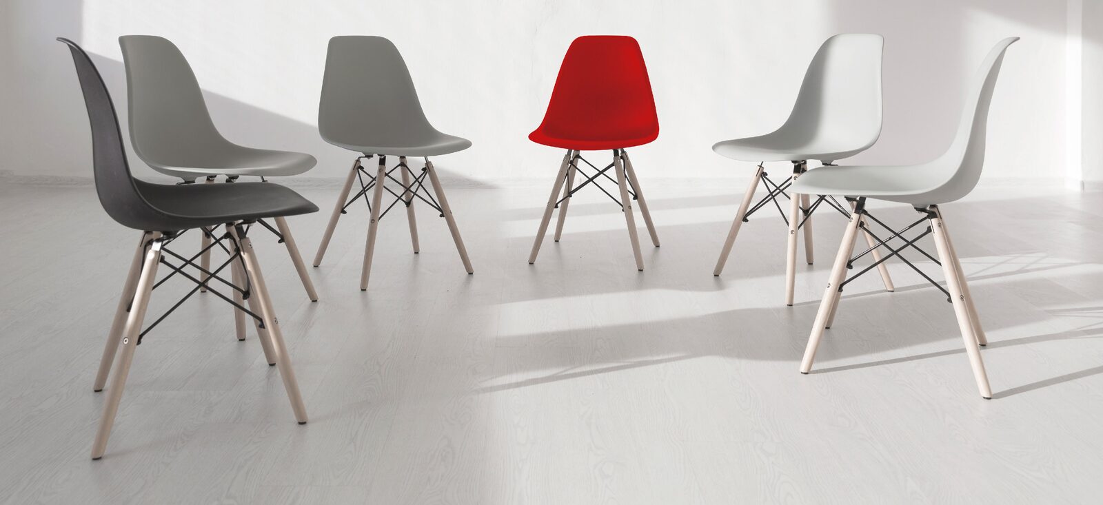 A row of chairs in an empty meeting room, one of them red